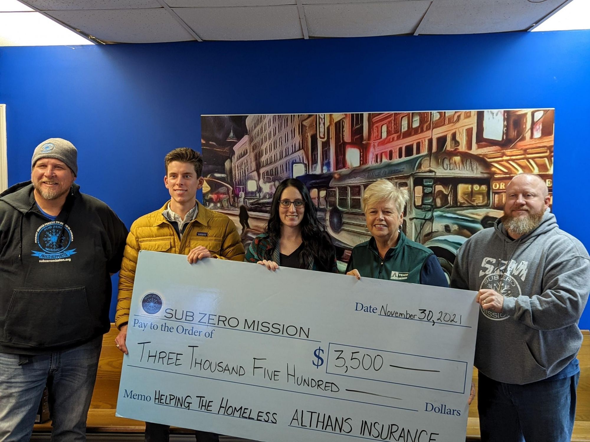 The sub zero mission team holding a large check